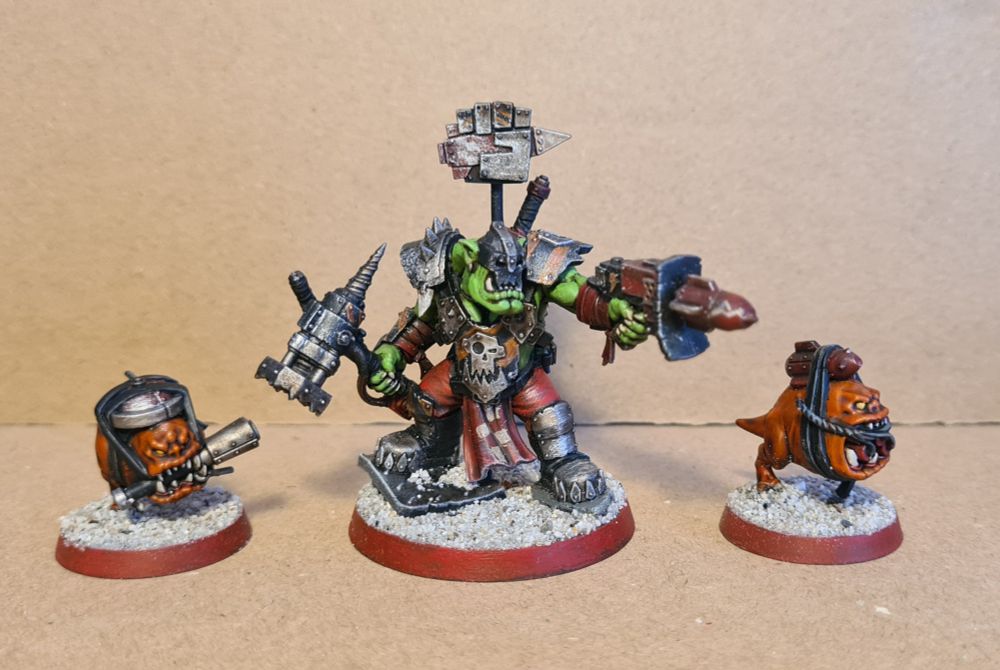 Boss Nob Tankbusta miniature armed with a smash hammer and a rokkit pistol, sided by two bomb squigs.