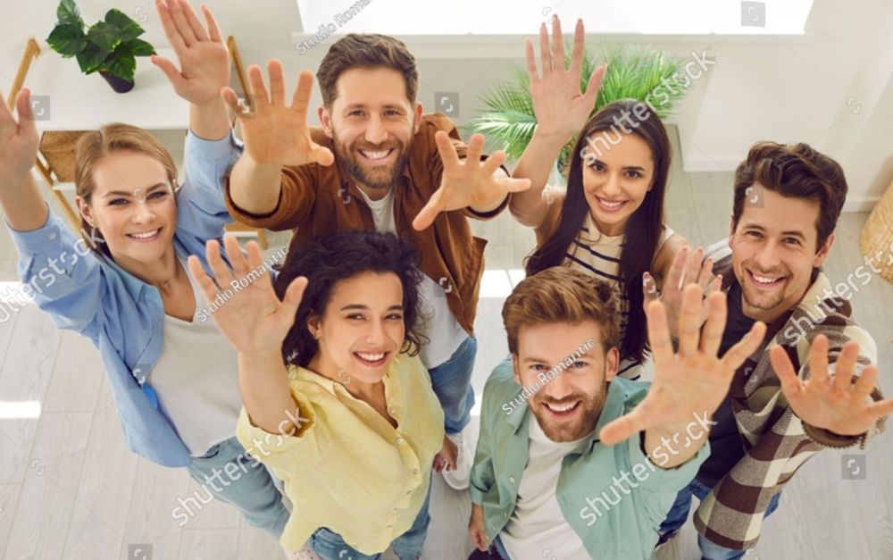 Photo from above of a group of people reaching up to the photographer