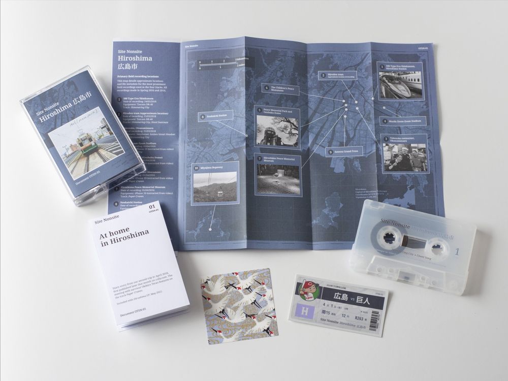 Cassette copy of Site Nonsite's Hiroshima EP, with contents displayed: cassette case and cover, diary entry, unfolded map insert, stickers and origami paper.
