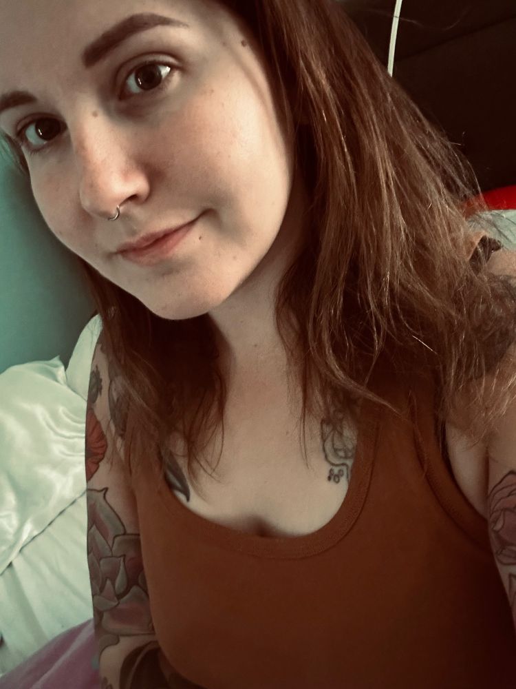 Selfie of girl with brown hair and tattoos