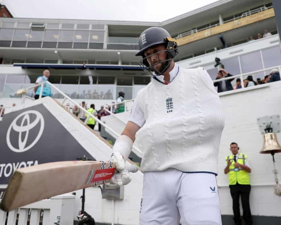 Chris Woakes coming out to bat with one arm in a sling. 