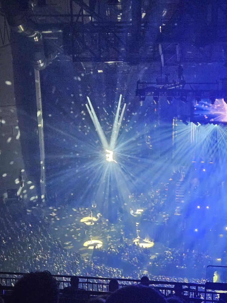 A silver acrobatic aerial dancer in four spotlights