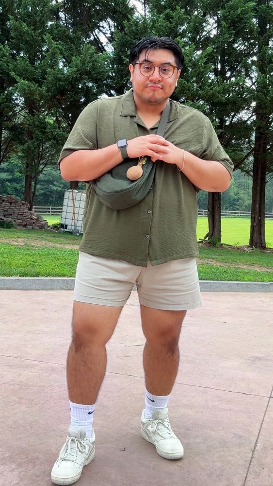 Ed wearing an olive green button down with khaki shorts, white socks and beige New Balance shoes.