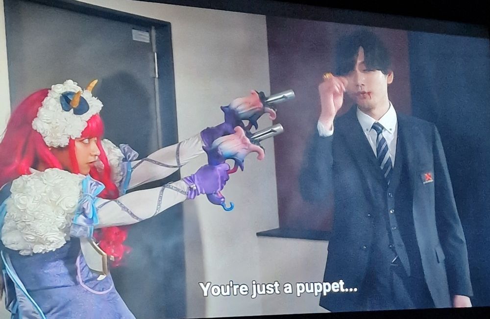 Lady Bouquet pointing her guns at a twat in a suit.