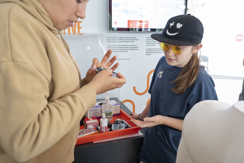 Sur un stand de démonstration, une jeune fille écoute attentivement les explications de l'animatrice.
