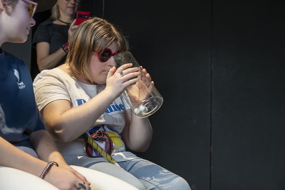 Une adolescente sent les odeurs diffusées dans un bocal en verre.