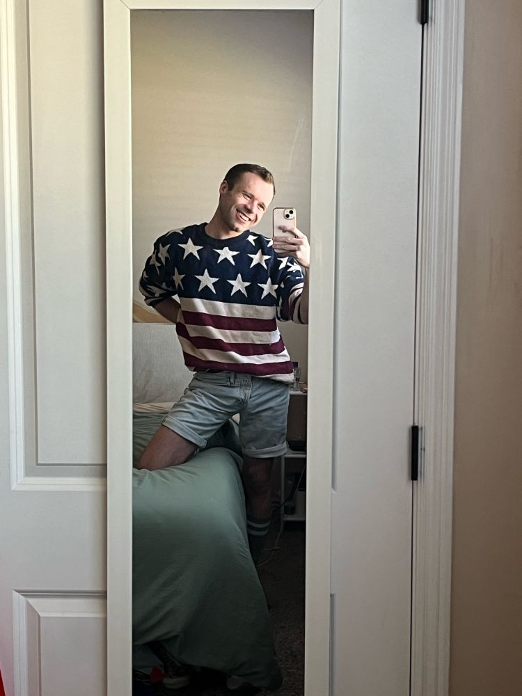 Calvin wearing a vintage red white and blue striped patriotic knit sweater