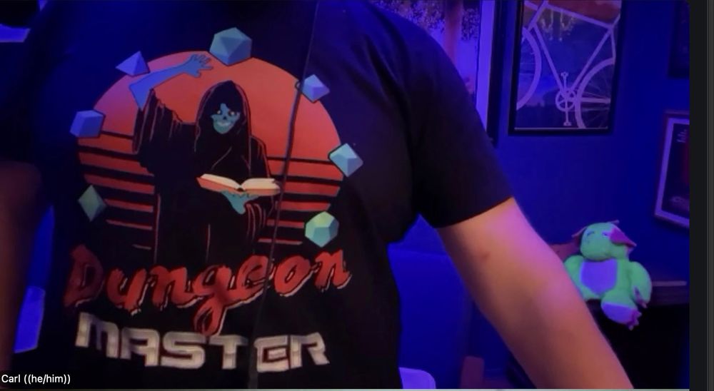 One of my tshirt designs with a Synthwave style Lich Dungeon Master holding a book surrounded by D&D dice, neon green-looking plush dragon in the background