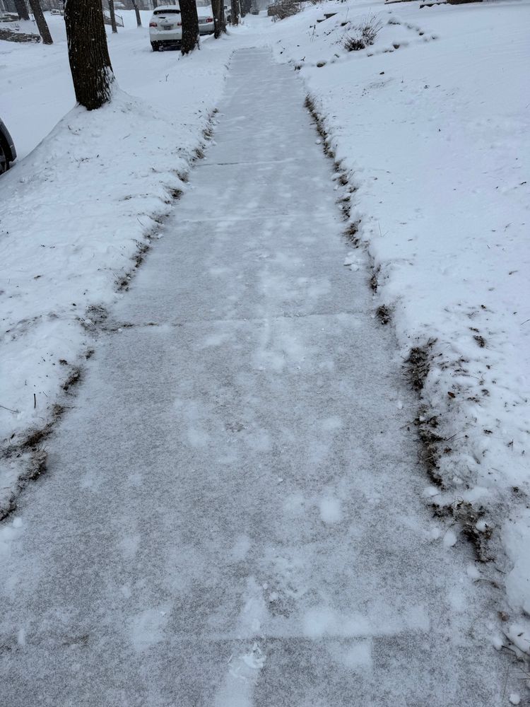 A length of sidewalk covered with a dusting of snow
