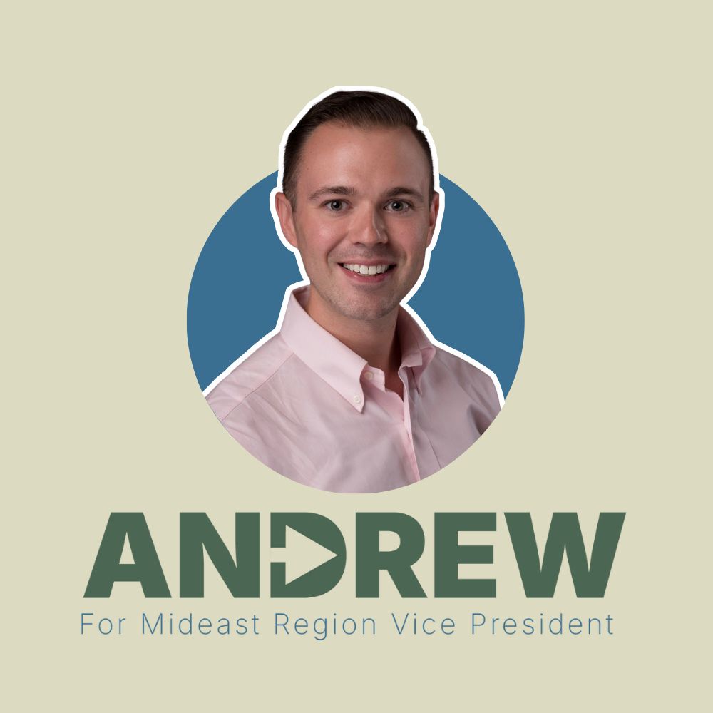 Portrait of Andrew Robinson smiling in a light pink button-down shirt, centered in front of a blue circle on a beige background. Below the photo, bold green text reads “ANDREW” with the “D” styled as a forward arrow. Underneath, smaller blue text reads “For Mideast Region Vice President.” Read more at vote for andrew dot org.