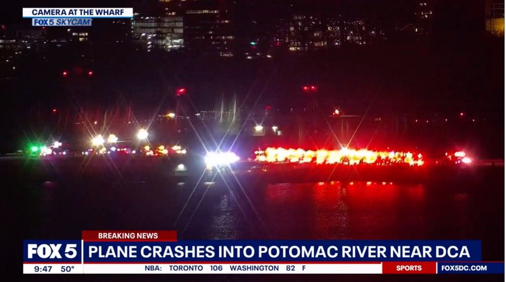 Nighttime photo captured by Fox 5 SkyCam showing emergency lights and vehicles on the Potomac River near Washington, D.C.’s Reagan National Airport (DCA) responding to a reported plane crash, with city lights visible in the background.