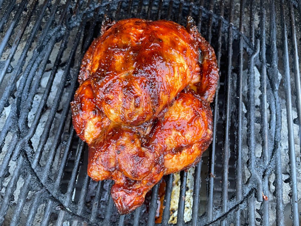 Whole chicken glazed with BBQ sauce.