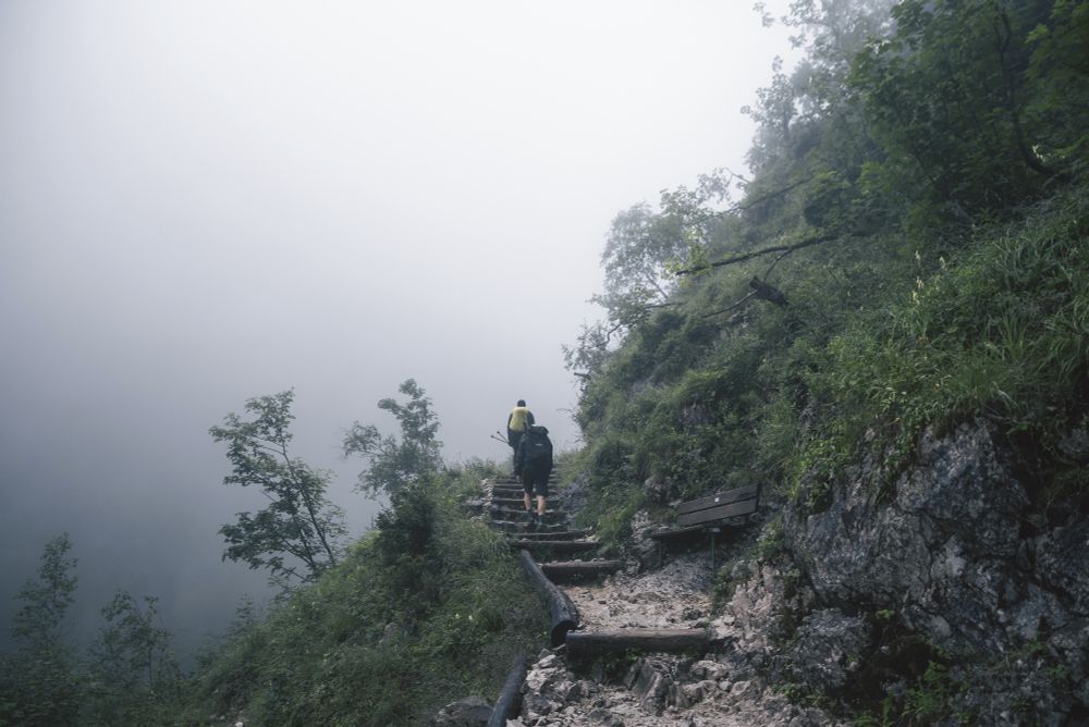 Two hikes going up a hiking path with low visibility. 