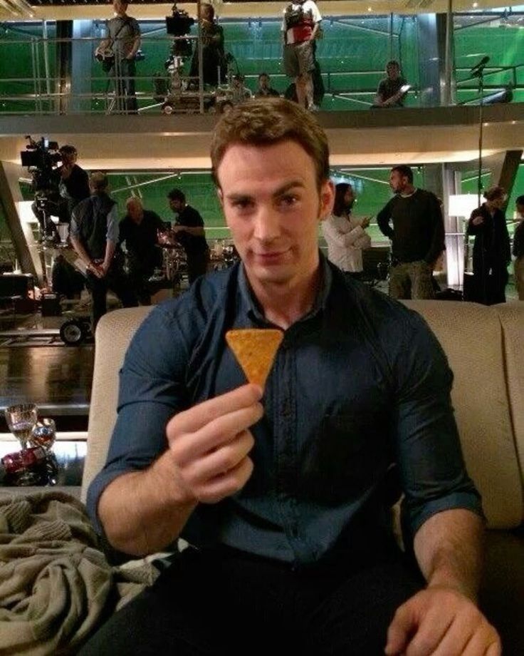 A younger Chris Evans holding a Dorito with a smug smile and raised eyebrow 