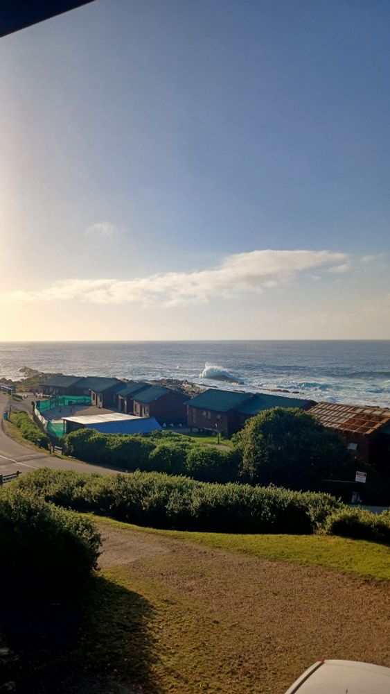 Sunrise over the ocean in South Africa's Eastern Cape. A row of cabins separate my view from the sea itself.