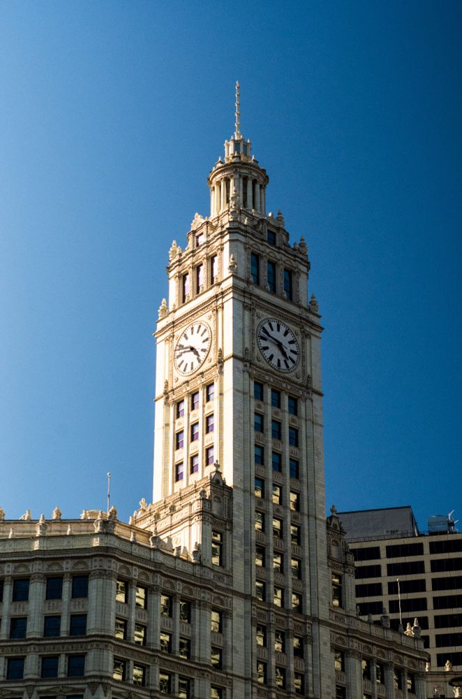 The Wrigley building in Chicago with the late afternoon sun striking one side against a stark blue, cloudless sky