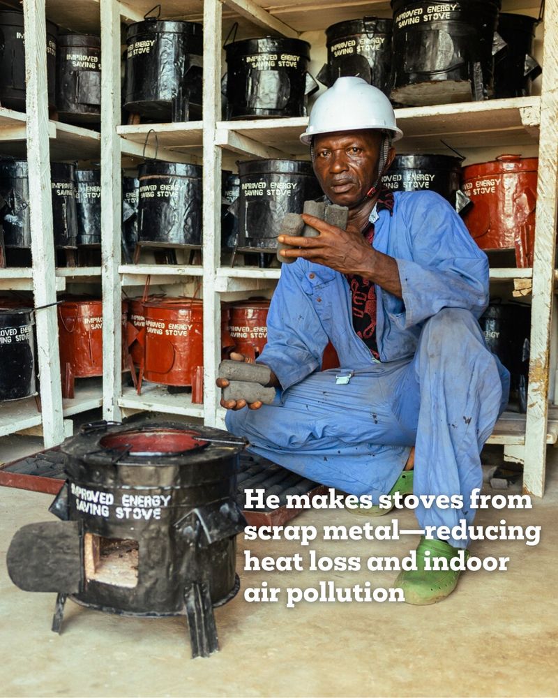 Image of Alfred with in front of a stove and holding briquettes with the text, 'He makes stoves from scrap metal—reducing heat loss and indoor air pollution'