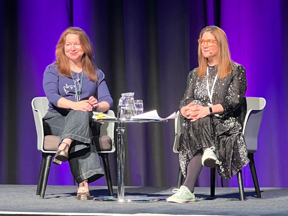 Dr rachel clarke and dr natasha wiggins sitting on stage