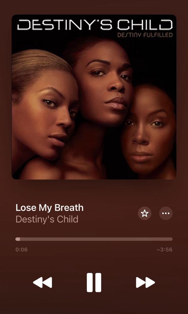 A picture of three Black women from the neck up (2004 Destiny’s Child). They’re huddled together staring, unsmiling, into the camera
