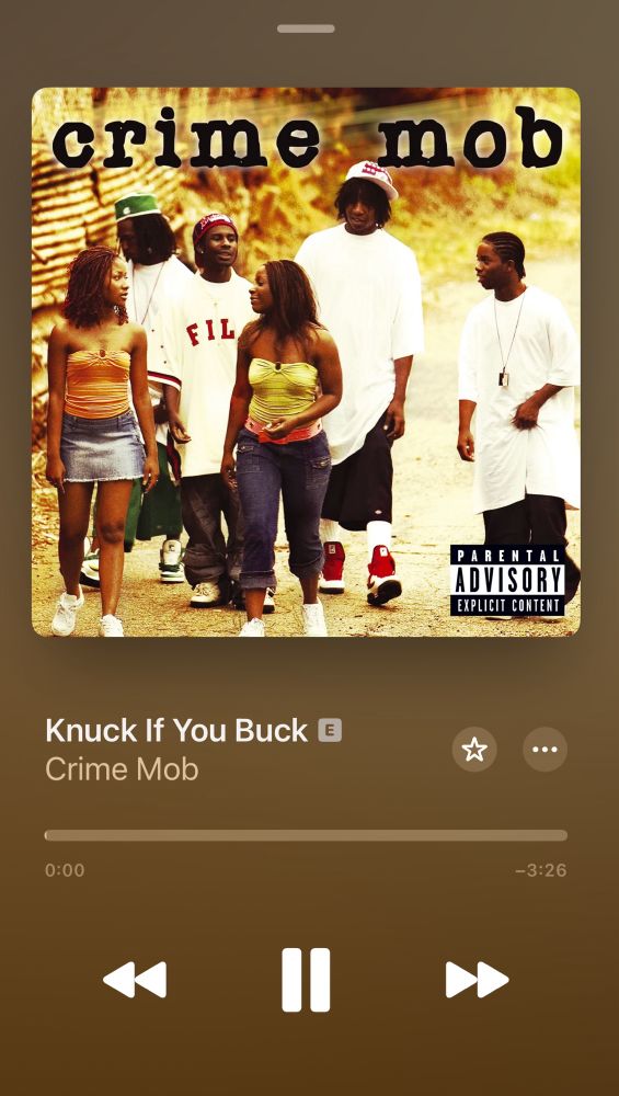 The members of Crime Mob walking down the road talking. The men in their 2000’s XL white tees and shants (oversized shorts long enough to be pants)