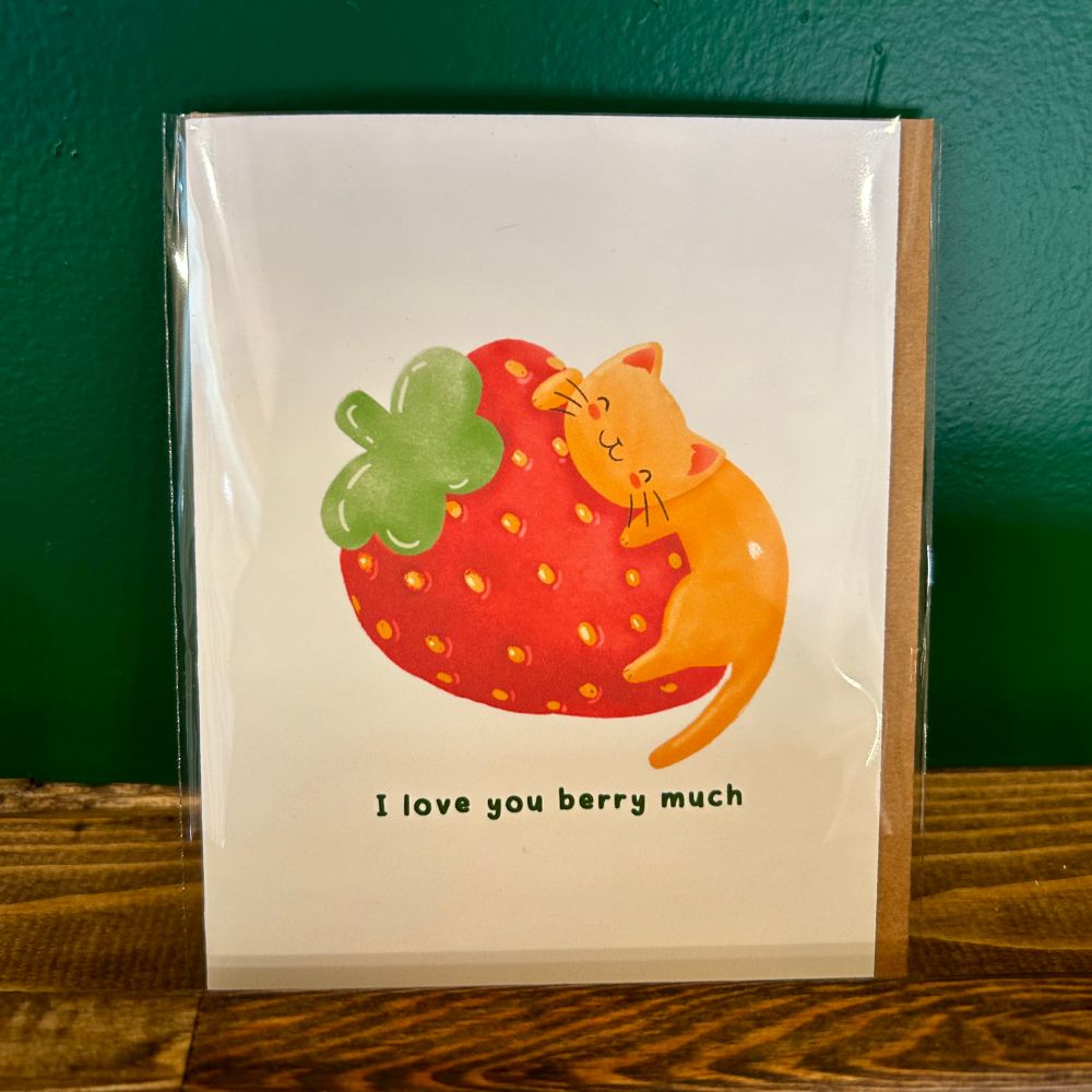 An orange cat on a strawberry. Text says “I love you berry much”.