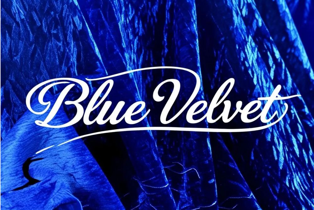 The words Blue Velvet, with a backdrop of blue velvet fabric.