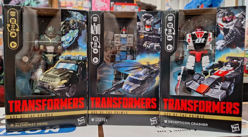 3 Transformers Generations figures from the new Age of Primes wave. Alchemist Prime on the left, Vortex in the middle, and Decepticon Crasher on the right.