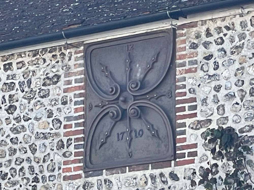 Iron plaque high on the front of a house in Steyning, West Sussex. It bears the date 1710.