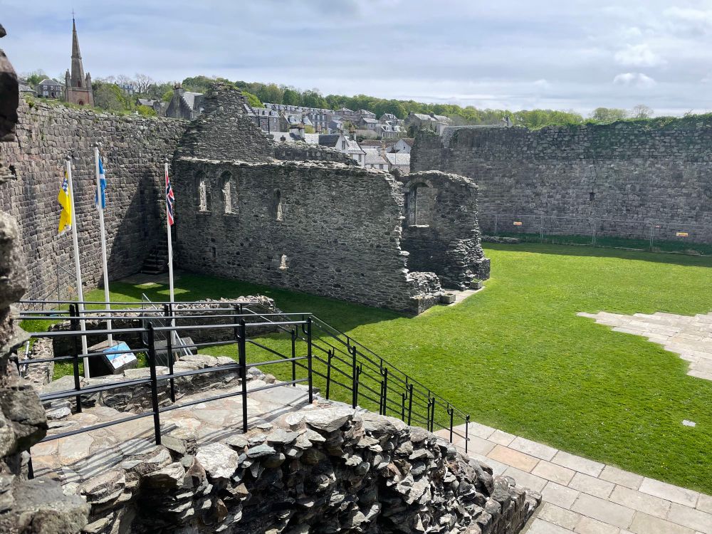 A view of the interior of Rothesay Castle from the gatehouse. The surviving building had a chapel on its first floor, the altar end marked by pairs of large traceried windows in the north and south walls. The west end of the building is missing.
