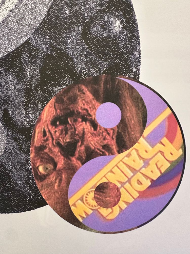 a closeup of a spread showing a yinyang with the crypt keeper from creepshow and the reading rainbow logo