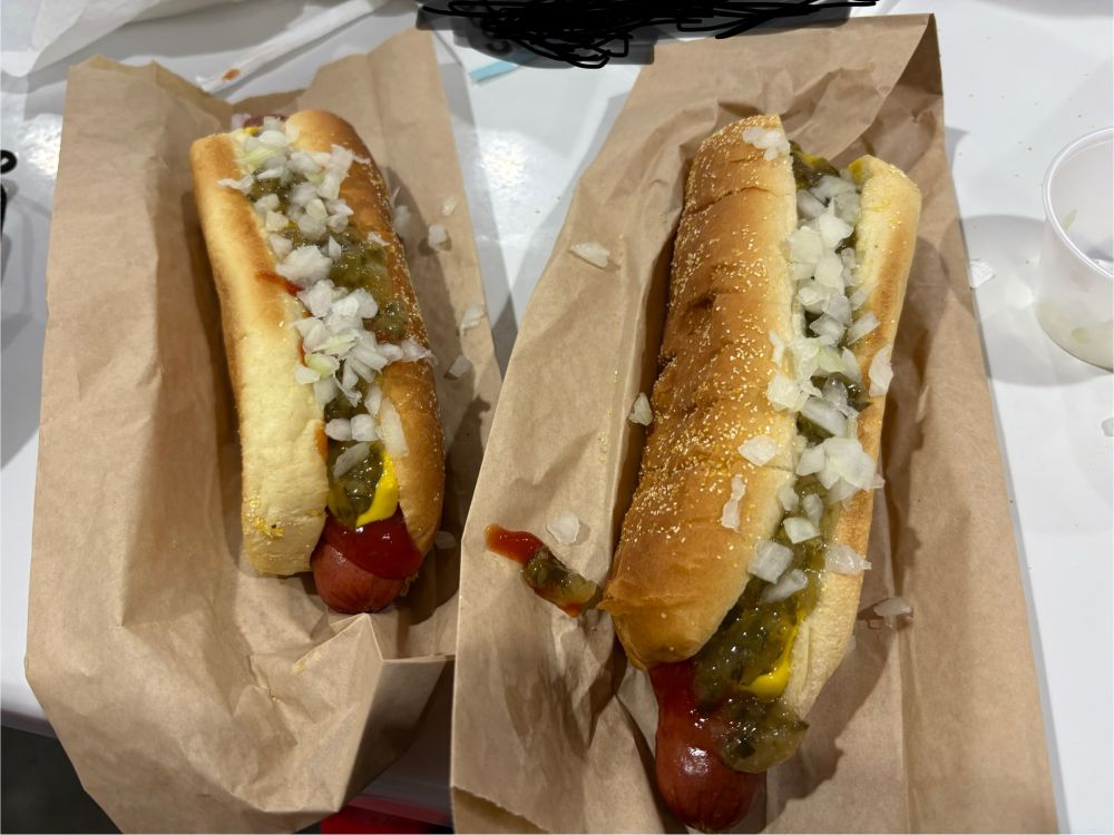 Two costco hot dogs with ketchup, mustard, relish, and onions