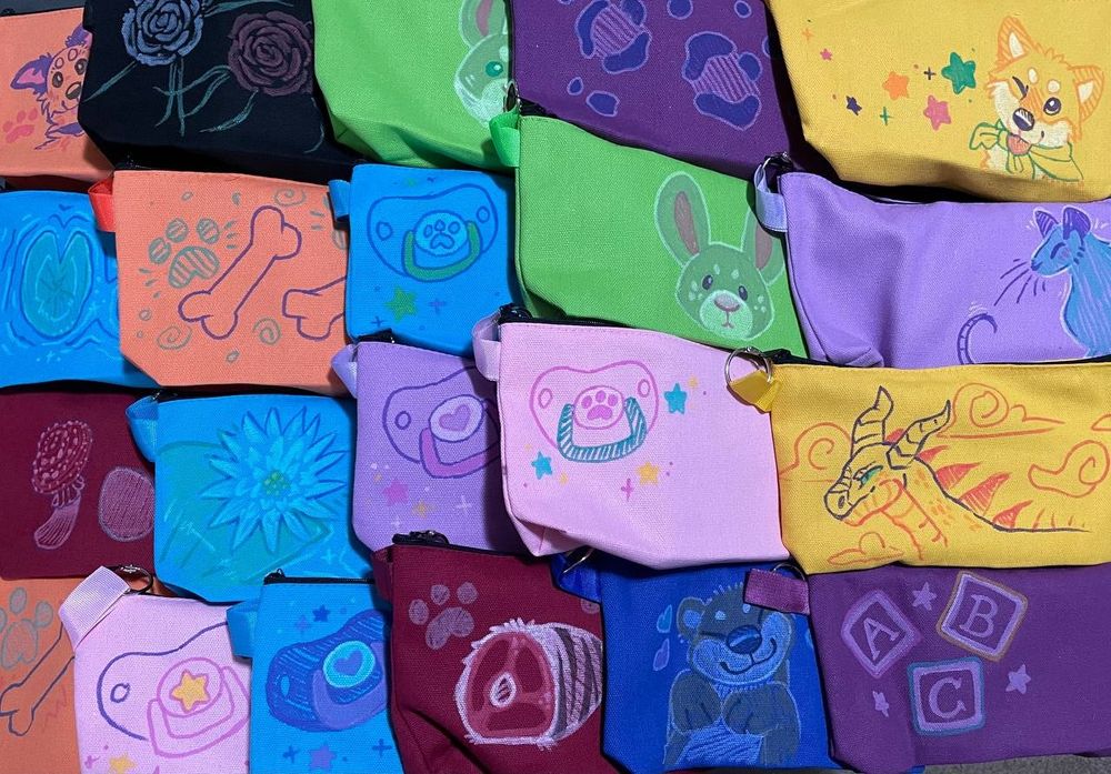 An assortment of cloth bag with animals and other things drawn on them. 