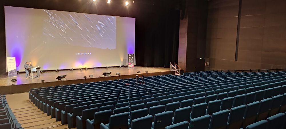 L'amphi A du palais des congrès de Bordeaux vide après ma présentation vu depuis le fond de la salle.
On y voit encore mon fond d'écran sur l'écran de la scène 