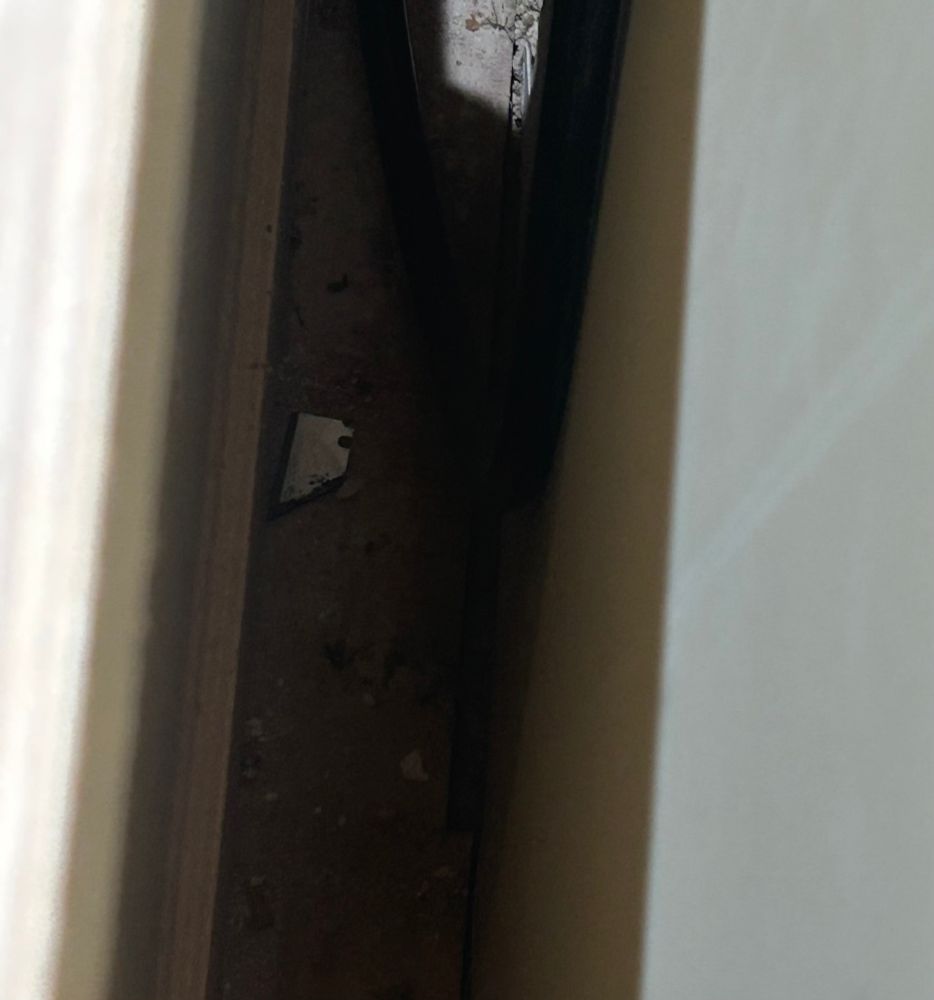 Broken razor blade behind cabinet 