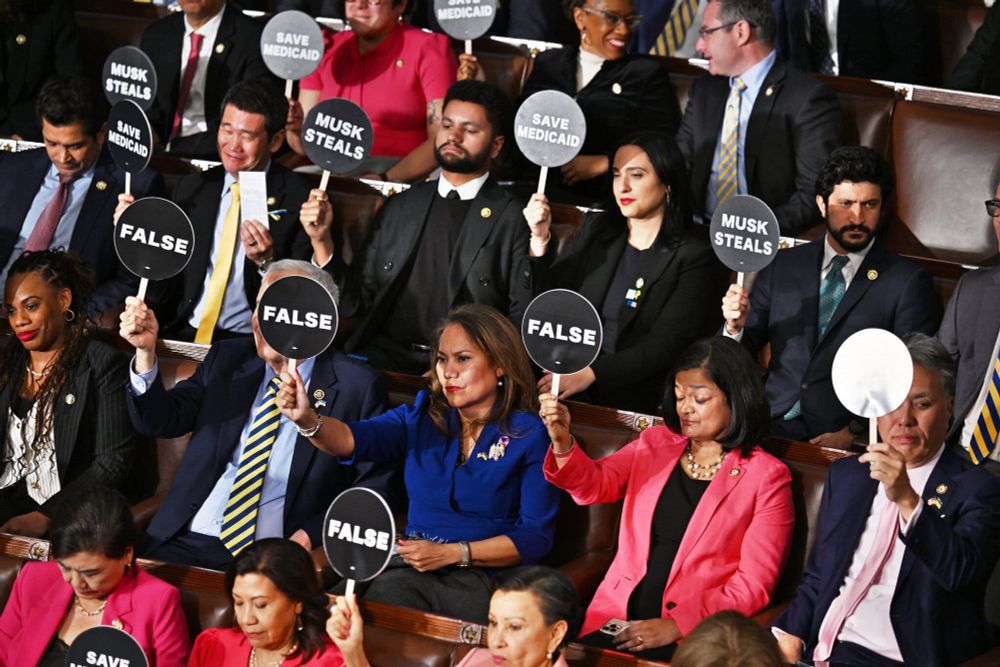 Congress holds up protest paddles.