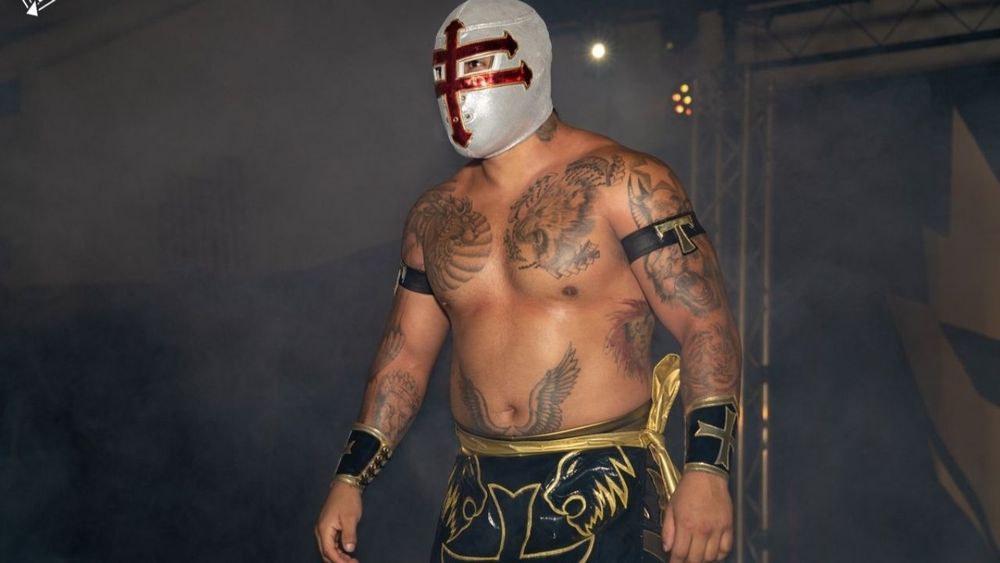 Luchador Templario is wearing a mask that is meant to resemble a knight's helmet, but mostly just looks like a cross made out of three arrows
