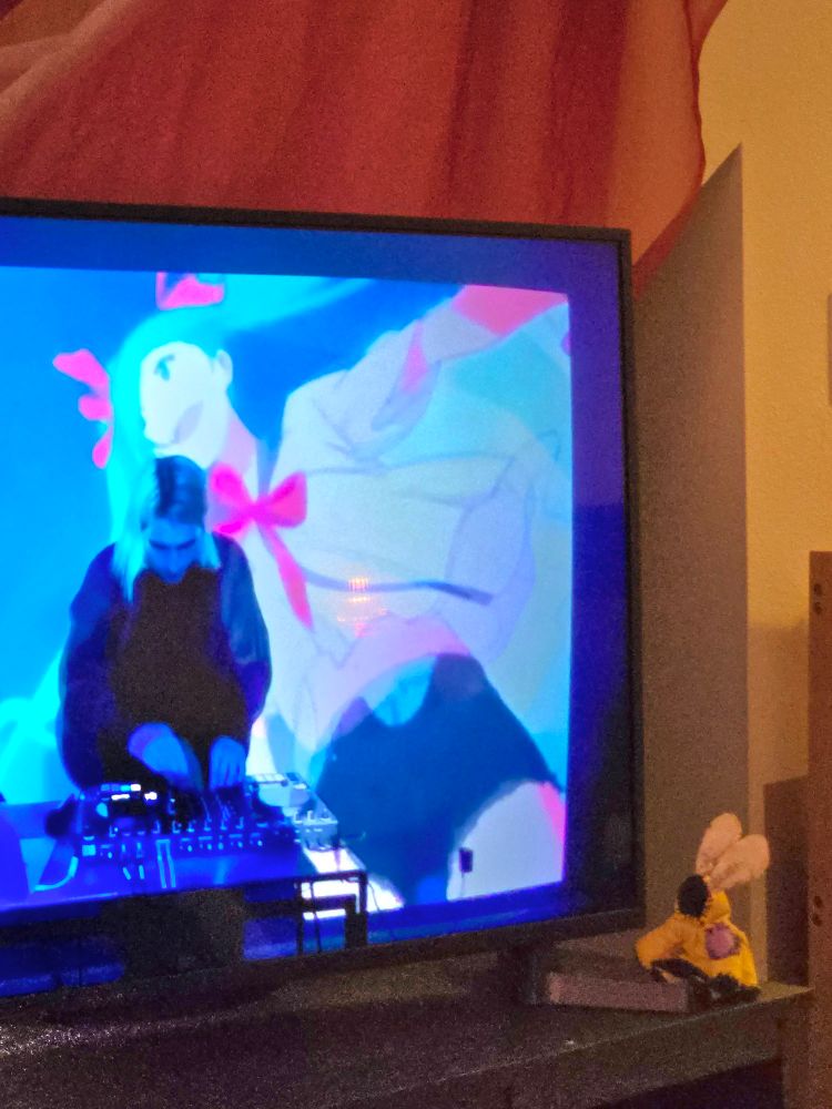 A cute stop motion puppet that consists of a cloak with two moth Antena sticking out, watches the Porter Robinson 2020 Secret Sky set. Specifically the end where Hatsune Miku is on screen. 