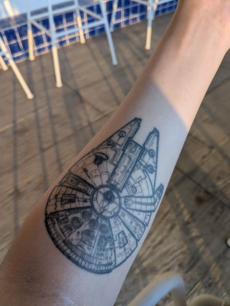 Photo de mon bras gauche où on peut voir mon tatouage du vaisseau Faucon Millenium de Star Wars