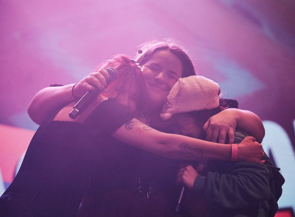 From right to left: Kathy-Chan, Cami-Cat, and Chi-chi. Embracing on the stage together in Texas for Nerdcore Party Con 2025