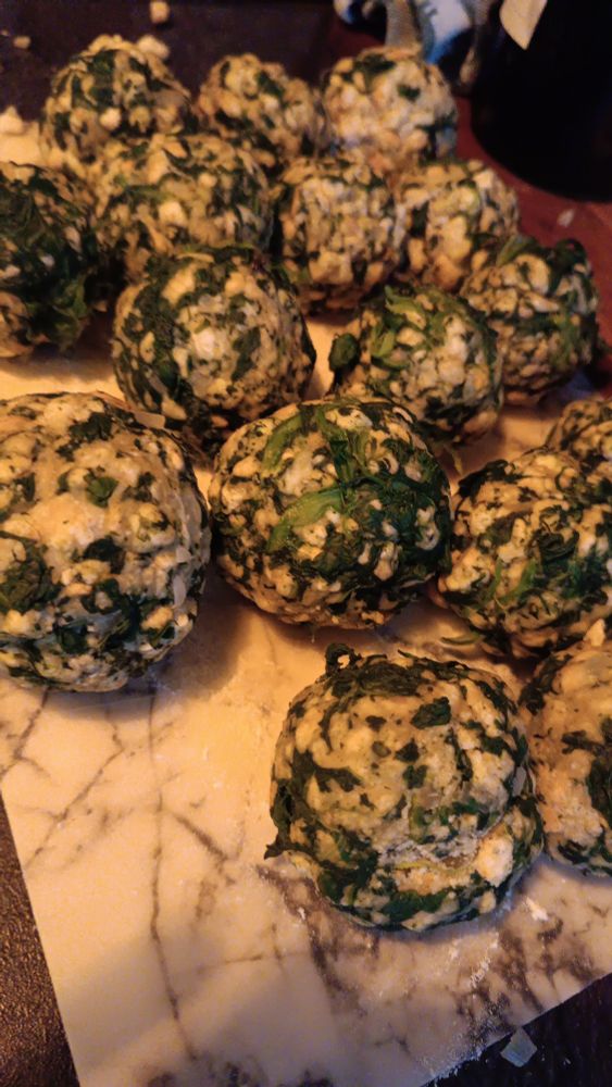 close up of a bunch of spinach knödel on a cutting board