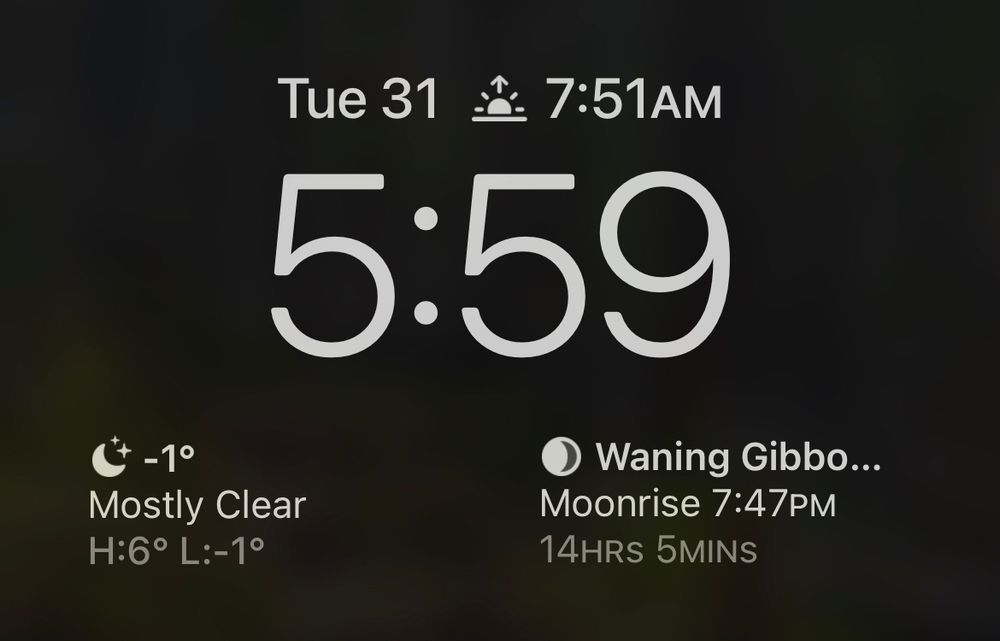Cropped image of a phone screenshot. The date is Tuesday October 31. The time is 5:59. Sunrise is 7:51 am. The weather widget on the left depicts the current weather as Mostly Clear with a high of 6 and a low of -1. The moon widget on the right denotes a Waning Gibbous moon with a Moonrise of 7:47 pm in 14 hours and 5 minutes.