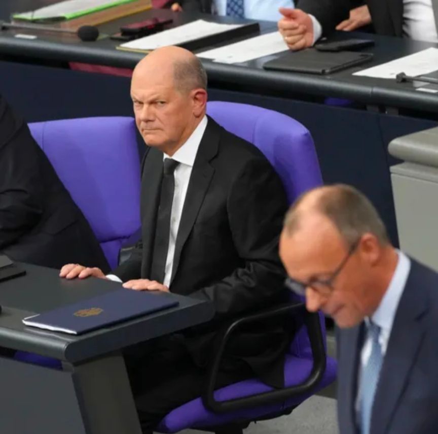 Kanzler Scholz guckt grimmig zu Merz
