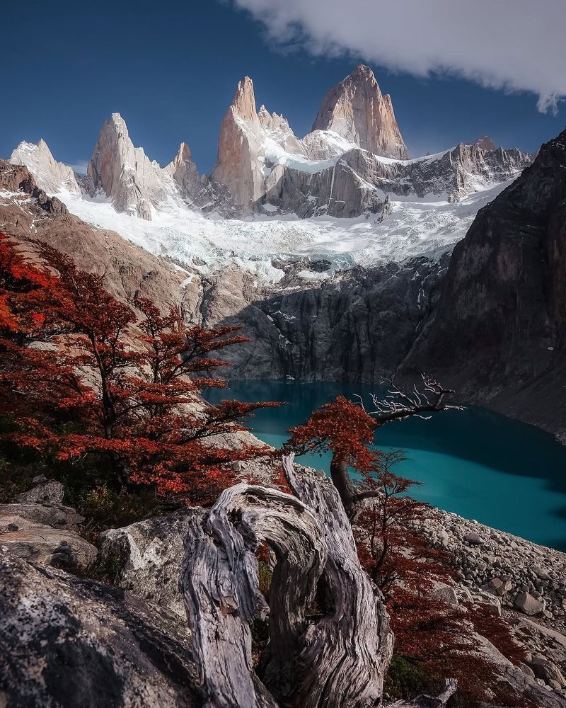 This photo is by Jenna Dixon (www.jennadixonphotography.com).

The photo was taken from the edge of a cliff overlooking a glacial lake surrounded by mountains with sheer faces. In the background is Cerro Chaltén, a mountain of many peaks, all jagged and towering.