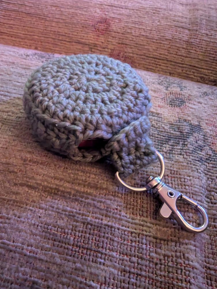 Crochet holder showing a tin of vaseline secured inside.