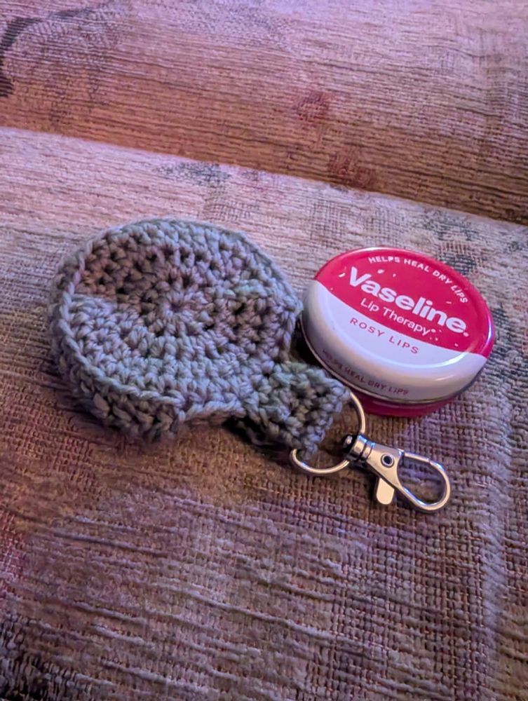 A crochet holder for the tin of vaseline next to it.