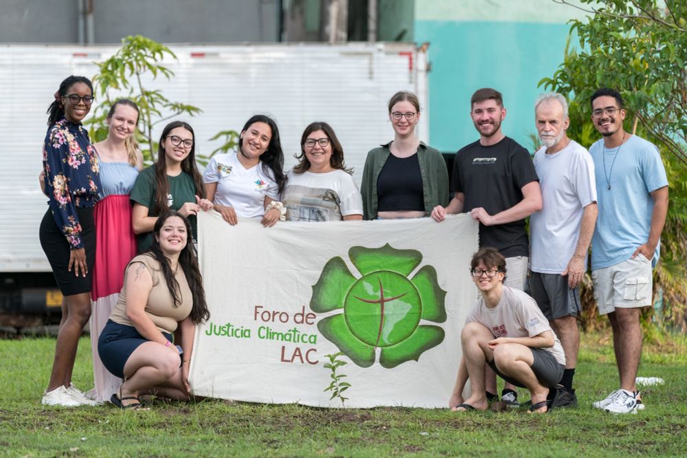 Lutheran World Federation delegates to COP30 gather around a tree they have planted outside the Evangelical Church of the Lutheran Confession in Brazil. 