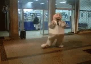 fat bald mascot guy bounces around sidewalk