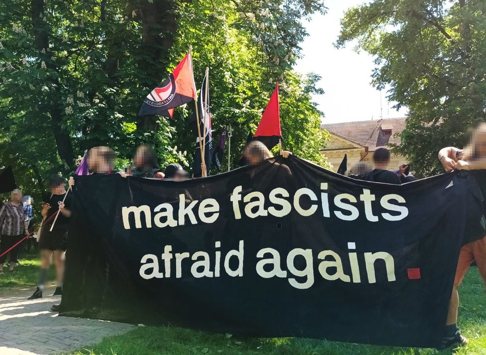 lidé s bannerem 'make fascists afraid again' na Střeleckém ostrově