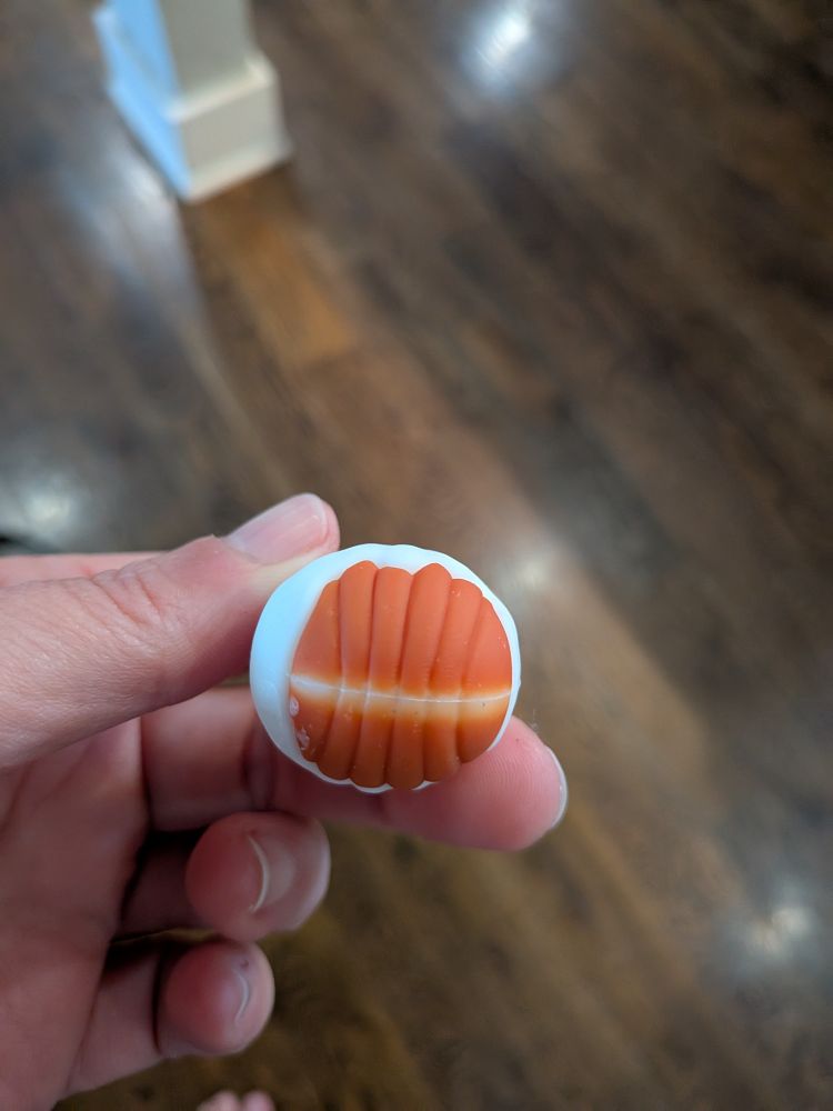 The bottom of the figurine showing the bottom of the orange pumpkin The pumpkin has ridges and a yellow line at the bottom which totally makes it look like a basketball!!