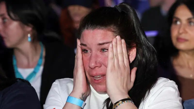 Reuters image, a woman crying and holding her face, taken from the BBC.